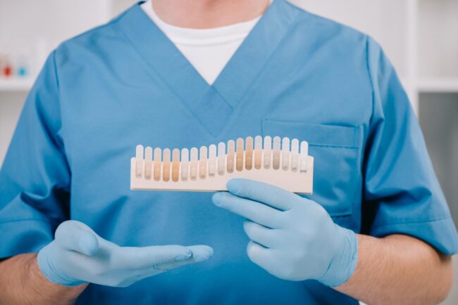 partial-view-of-dentist-holding-teeth-color-palett-2024-11-19-09-36-49-utc